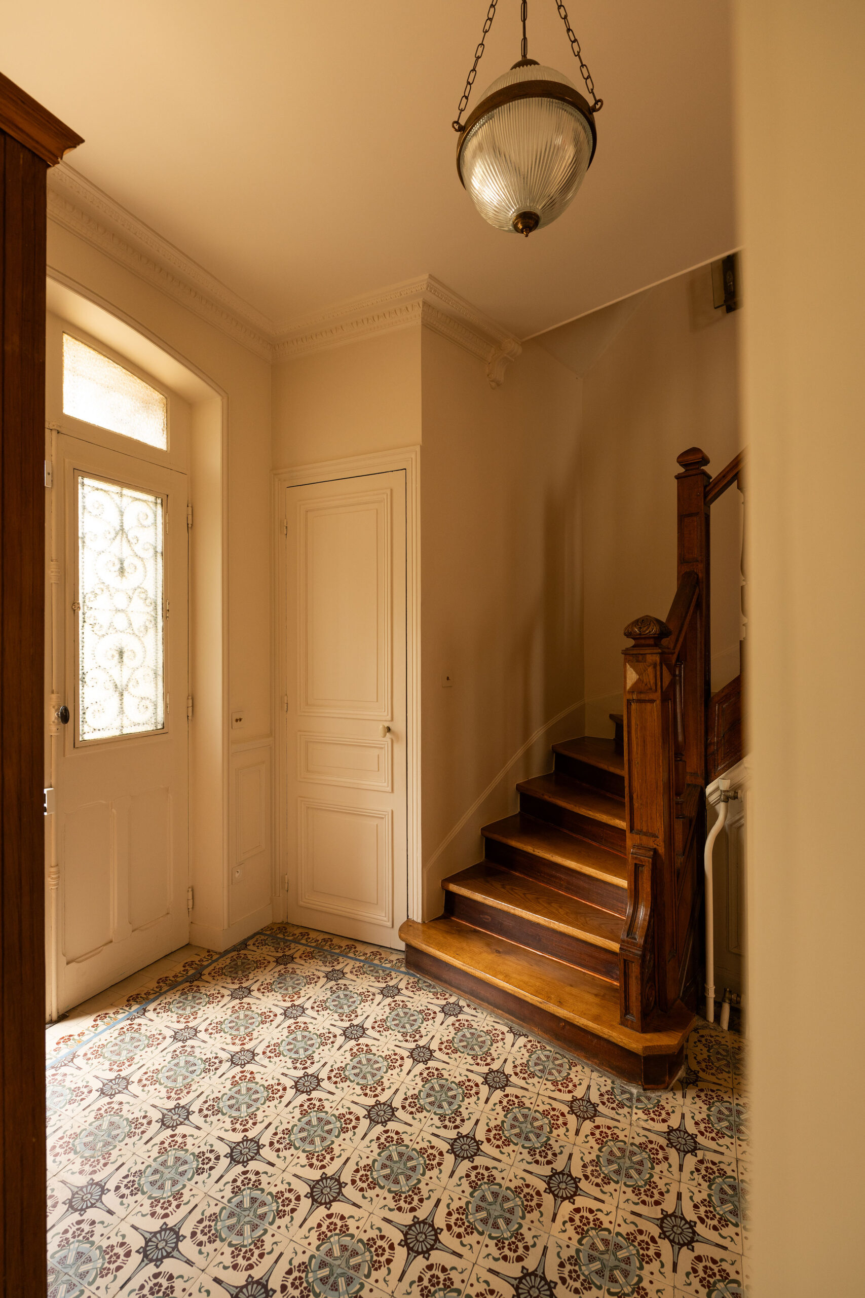 Entrée avec carreaux de ciment et escalier en bois